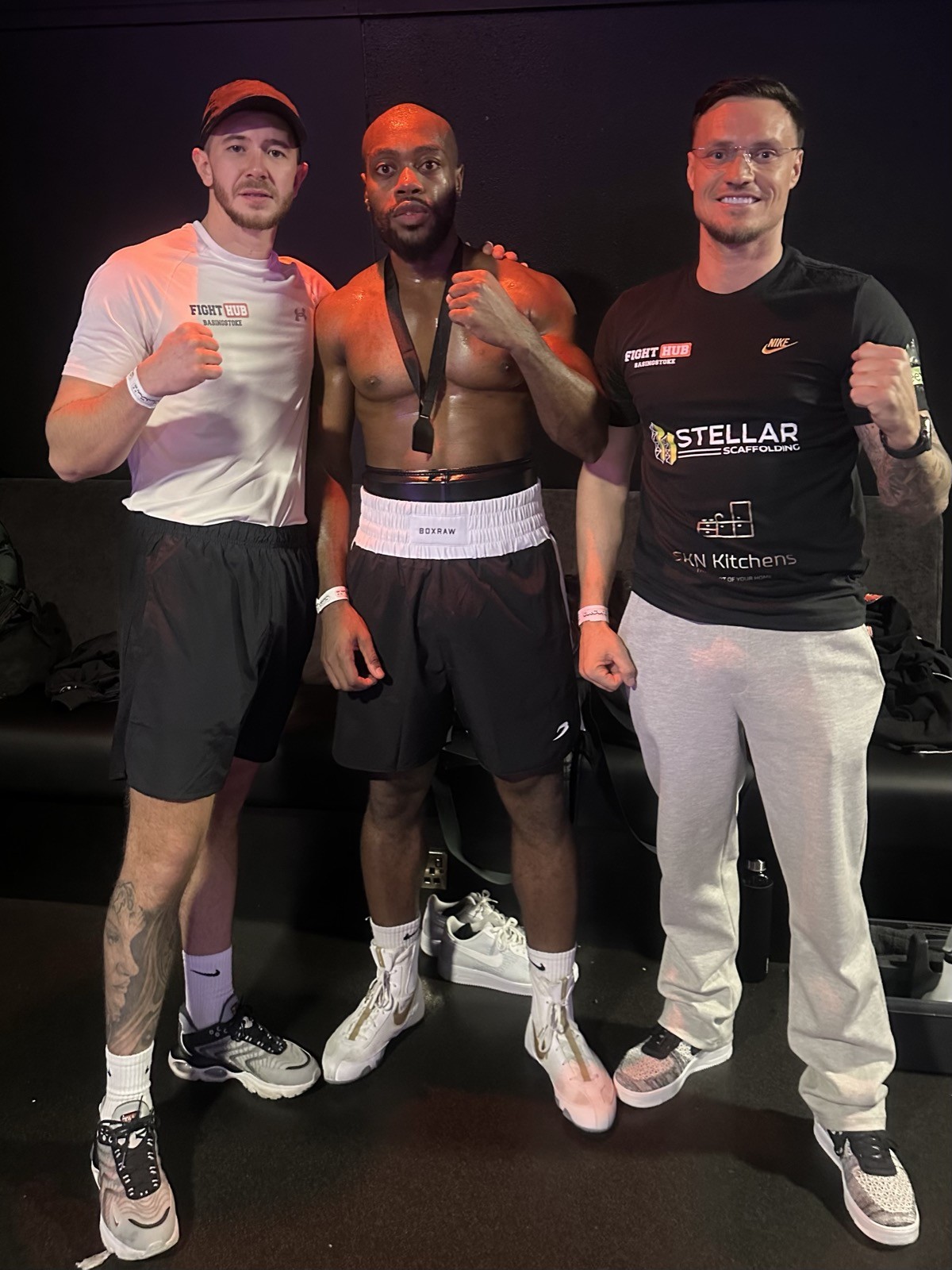 Fighter with coaches and medal after fight night