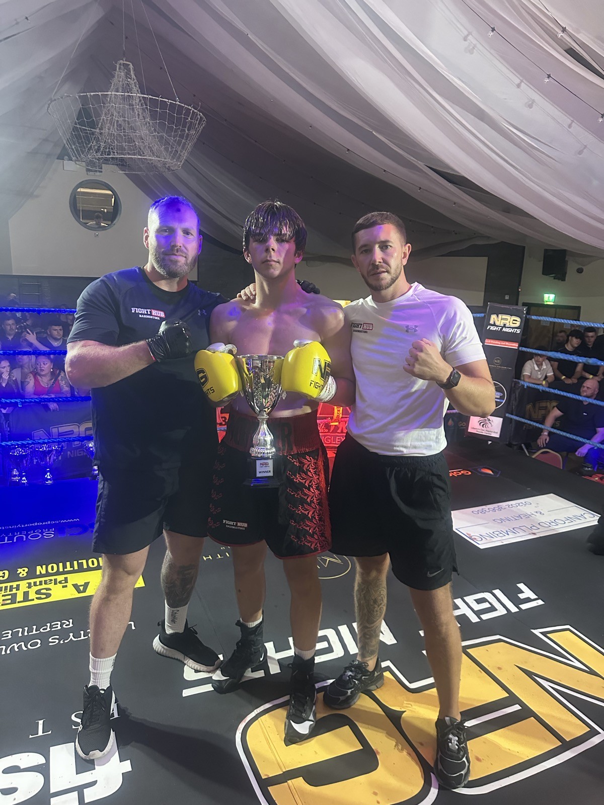 Young fighter with trophy and coaches at Fight Hub Basingstoke